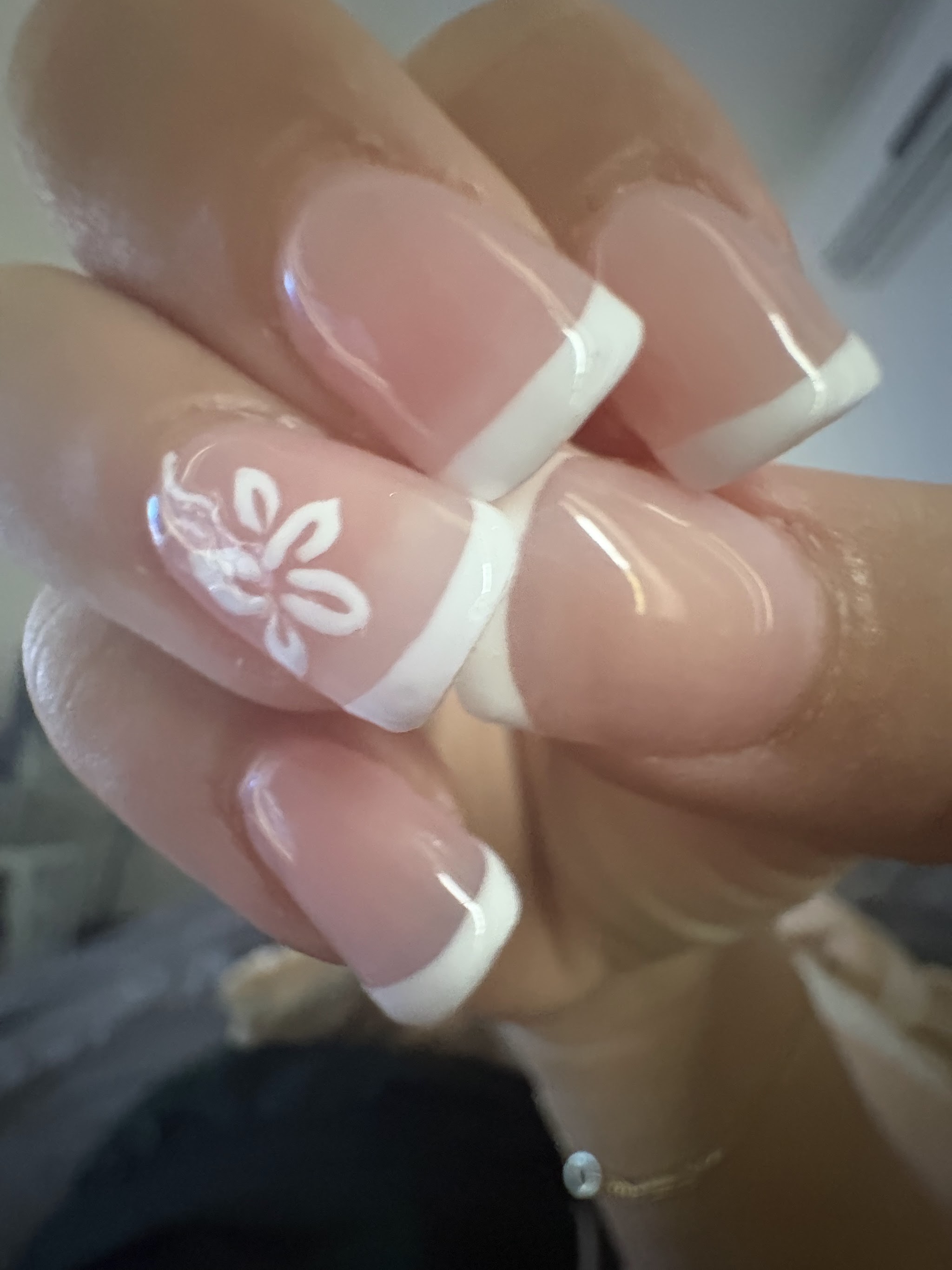 White French tips with a hand-painted flower accent